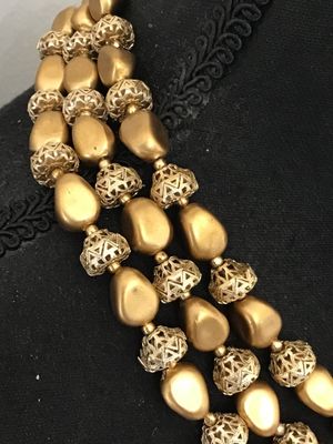 Sale Photo Thumbnail #23: A vintage mid-century style multi-strand necklace featuring three layers of matte gold-tone nugget-shaped beads alternating with intricate openwork filigree metal spacer beads. Includes an adjustable hook-and-tail clasp with gold-tone bead extender. Good 