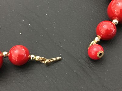 Sale Photo Thumbnail #29: A classic strand necklace featuring vibrant glossy red round beads separated by small gold-tone spacer beads. Features a traditional gold-tone hook and end bead clasp closure. Appears to be in good vintage condition with minimal surface wear. Please revie