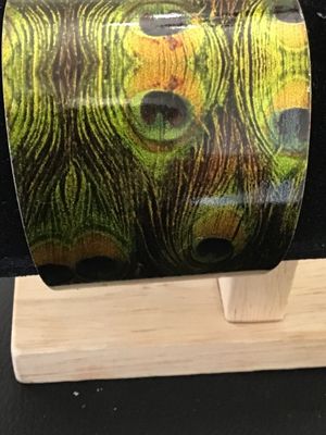 Sale Photo Thumbnail #39: A wide metal cuff bracelet featuring a vivid glossy peacock feather pattern on the exterior with a gold-tone brass interior finish. Measures approximately 1.75 to 2 inches wide. Shows minor wear along the edges and interior surface, but overall in good, w