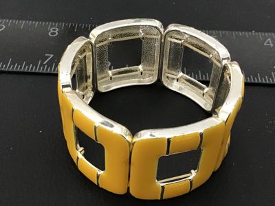 Sale Photo Thumbnail #42: A stretch bracelet featuring square cut-out links filled with bright yellow enamel on a silver-tone metal frame. Elastic cord assembly allows for comfortable, flexible fit. Shows light surface wear consistent with previous use.
