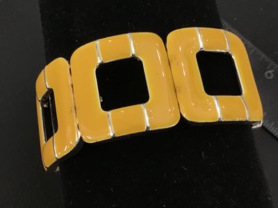 Sale Photo Thumbnail #41: A stretch bracelet featuring square cut-out links filled with bright yellow enamel on a silver-tone metal frame. Elastic cord assembly allows for comfortable, flexible fit. Shows light surface wear consistent with previous use.