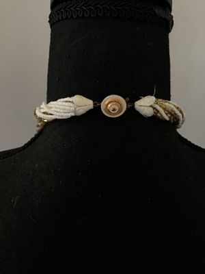 Sale Photo Thumbnail #43: Multi-strand twisted torsade necklace featuring alternating strands of white seed beads and metallic gold-tone glass bugle beads. It features decorative white molded end caps and a gold-tone push-in box clasp with a sunburst pattern. In good vintage condi