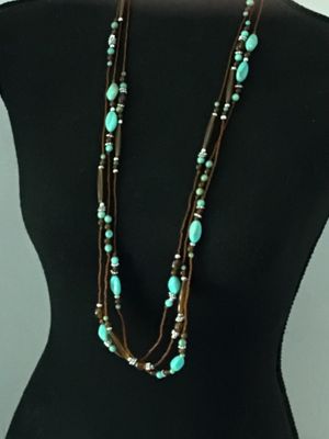 Sale Photo Thumbnail #57: Multi-strand layered necklace featuring turquoise-colored focal beads, amber-tone glass or acrylic spacer beads, silver-tone accent spacers, and brown seed bead strands. Good pre-owned condition with no visible damage or broken strands.