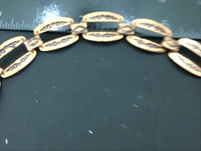 Sale Photo Thumbnail #78: Vintage copper link bracelet featuring stamped geometric designs with black enamel or niello accent fill. Features open cut-out oval links connected by decorative connector bars and a hook/ring clasp. Measures approximately 7 to 7.5 inches in length. Show