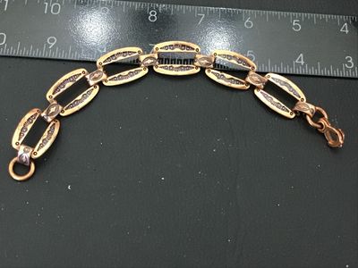 Sale Photo Thumbnail #79: Vintage copper link bracelet featuring stamped geometric designs with black enamel or niello accent fill. Features open cut-out oval links connected by decorative connector bars and a hook/ring clasp. Measures approximately 7 to 7.5 inches in length. Show