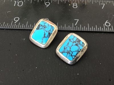 Sale Photo Thumbnail #113: Pair of vintage clip-on earrings featuring bezel-set rectangular turquoise stones with fine dark matrix. Crafting in sterling silver, stamped '925' on the clip findings. Each earring measures approximately 3/4 inch long. In good pre-owned condition with s