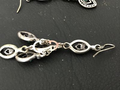 Sale Photo Thumbnail #123: Pair of ornate silver-tone chandelier drop earrings featuring marquee-shaped filigree elements, small turquoise-colored cabochons, and clear crystal accents. Wire fishhook ear wires. Measure approximately 2.5 inches in length. In good condition with light