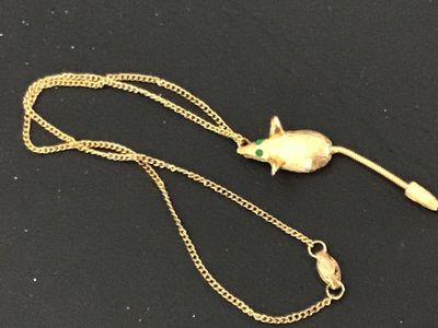 Sale Photo Thumbnail #130: Vintage gold-tone chain necklace featuring a textured mouse pendant with green rhinestone eyes and a flexible snake chain tail. The pendant has a brushed finish detail. Includes a fold-over or spring clasp mechanism. Good vintage condition with light, sta