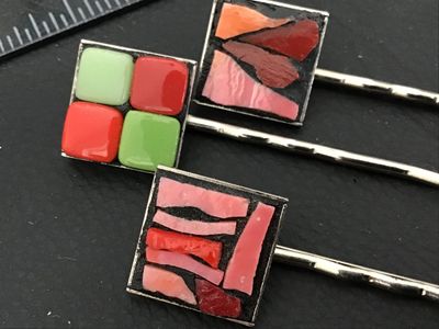 Sale Photo Thumbnail #134: A lot of three decorative silver-tone hair bobby pins featuring square mosaic and enamel tile tops. Includes one featuring green and red grid tiles and two featuring mosaic glass in shades of pink, red, and coral set in dark grout. Each pin measures appro