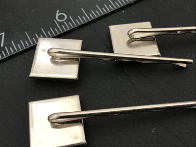 Sale Photo Thumbnail #136: A lot of three decorative silver-tone hair bobby pins featuring square mosaic and enamel tile tops. Includes one featuring green and red grid tiles and two featuring mosaic glass in shades of pink, red, and coral set in dark grout. Each pin measures appro