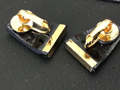 Sale Photo Thumbnail #142: Pair of vintage clip-on earrings featuring a trapezoid shape with an iridescent purple/blue finish and gold-tone bar accents. Gold-tone clip-on hardware on the reverse. Measurements are approximately 1 inch in length as shown against the ruler. Showing mi