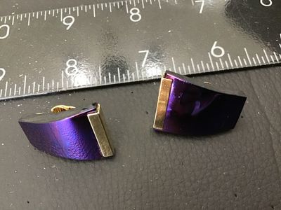 Sale Photo Thumbnail #143: Pair of vintage clip-on earrings featuring a trapezoid shape with an iridescent purple/blue finish and gold-tone bar accents. Gold-tone clip-on hardware on the reverse. Measurements are approximately 1 inch in length as shown against the ruler. Showing mi