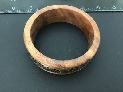 Sale Photo Thumbnail #17: A vintage bangle bracelet crafted from natural wood with an inset center band of openwork brass filigree. Shows light pre-owned wear consistent with age. Measures approximately 3 inches in outer diameter.