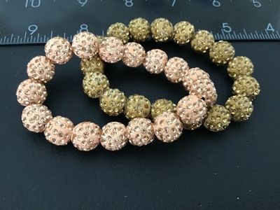 Sale Photo Thumbnail #25: Pair of beaded stretch bracelets featuring pave rhinestone 'disco ball' style beads in light pink/blush and gold tones. Good condition with no missing stones visible.