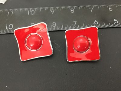 Sale Photo Thumbnail #26: Pair of bold retro-style square clip-on earrings featuring vibrant red enamel and a central domed cabochon set in silver-tone metal with a hammered back finish. Clip-on backs are functional and fitted with rubber comfort pads. Measure approximately 1.25 i