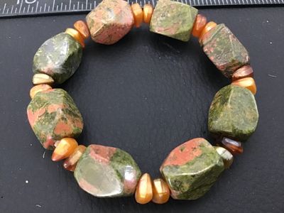 Sale Photo Thumbnail #32: A stretch beaded bracelet featuring large, faceted chunky unakite stone beads in green and pink hues, accented with smaller golden and amber-colored accent beads. Appears in good pre-owned condition with natural gemstone variations.