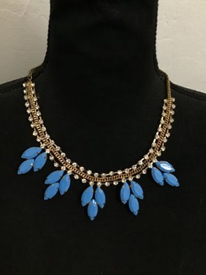 Sale Photo Thumbnail #70: A striking statement necklace featuring clear rhinestone chain links accented with a center gold-tone curblink chain, adorned with cluster dangles of bright blue opaque navette-cut stones in prong settings. Appears to be in good condition with all stones 