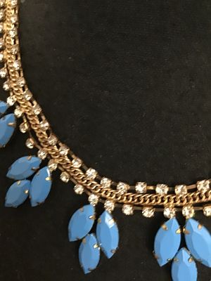Sale Photo Thumbnail #71: A striking statement necklace featuring clear rhinestone chain links accented with a center gold-tone curblink chain, adorned with cluster dangles of bright blue opaque navette-cut stones in prong settings. Appears to be in good condition with all stones 