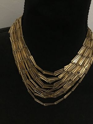 Sale Photo Thumbnail #86: A striking vintage multi-strand statement necklace featuring tiered rows of gold-tone bar-shaped links. Designed with a hook-and-tail clasp featuring a decorative sphere end cap. The necklace shows light wear consistent with age, with all strands intact a