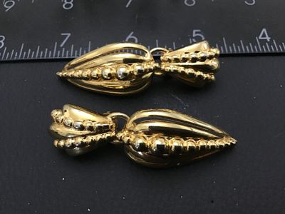 Sale Photo Thumbnail #129: Pair of vintage gold-tone clip-on drop earrings featuring a ribbed, tear-drop shape design with beaded texture accents. Earrings measure approximately 2.5 inches in length. In good condition with minor surface wear consistent with age.