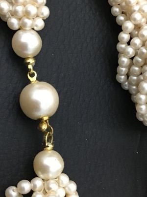 Sale Photo Thumbnail #137: Multi-strand faux pearl necklace featuring a knotted detail design in front and gold-tone spacer accent beads near the closure. Appears to be in good vintage condition with gentle surface wear. Perfect for elegant or formal occasions.