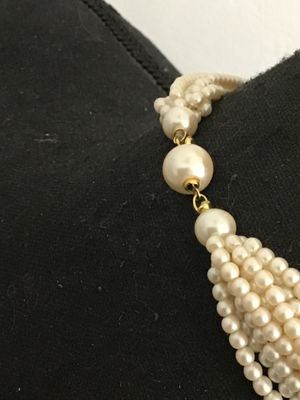 Sale Photo Thumbnail #138: Multi-strand faux pearl necklace featuring a knotted detail design in front and gold-tone spacer accent beads near the closure. Appears to be in good vintage condition with gentle surface wear. Perfect for elegant or formal occasions.