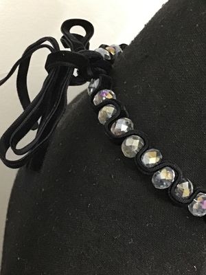 Sale Photo Thumbnail #143: Black velvet ribbon choker necklace featuring woven faceted glass or crystal beads with an aurora borealis iridescent finish. Ties in the back with adjustable fabric ribbons. Appears to be in good pre-owned condition with no loose or missing beads visible