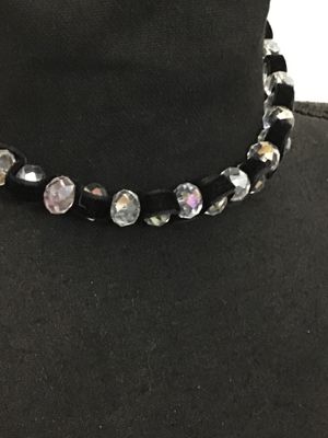 Sale Photo Thumbnail #141: Black velvet ribbon choker necklace featuring woven faceted glass or crystal beads with an aurora borealis iridescent finish. Ties in the back with adjustable fabric ribbons. Appears to be in good pre-owned condition with no loose or missing beads visible