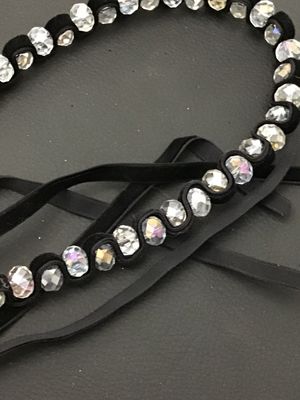 Sale Photo Thumbnail #142: Black velvet ribbon choker necklace featuring woven faceted glass or crystal beads with an aurora borealis iridescent finish. Ties in the back with adjustable fabric ribbons. Appears to be in good pre-owned condition with no loose or missing beads visible