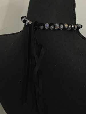 Sale Photo Thumbnail #145: Black velvet ribbon choker necklace featuring woven faceted glass or crystal beads with an aurora borealis iridescent finish. Ties in the back with adjustable fabric ribbons. Appears to be in good pre-owned condition with no loose or missing beads visible