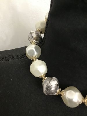 Sale Photo Thumbnail #151: Vintage single-strand choker style statement necklace featuring large baroque-style faux pearl beads alternating with gray and white swirled resin/plastic beads, accented with filigree end caps. Features a J-hook clasp stamped 'JAPAN' with an adjustable p