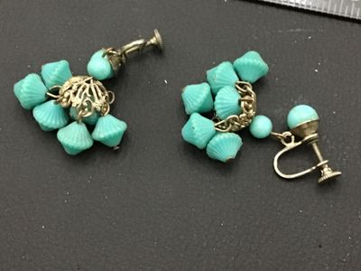 Sale Photo Thumbnail #179: Pair of vintage screw-back dangle earrings featuring bright turquoise blue molded plastic or glass beads cluster-suspended from filigree metal caps. Shows light age-appropriate patina to the metal hardware.