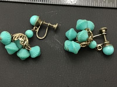 Sale Photo Thumbnail #180: Pair of vintage screw-back dangle earrings featuring bright turquoise blue molded plastic or glass beads cluster-suspended from filigree metal caps. Shows light age-appropriate patina to the metal hardware.