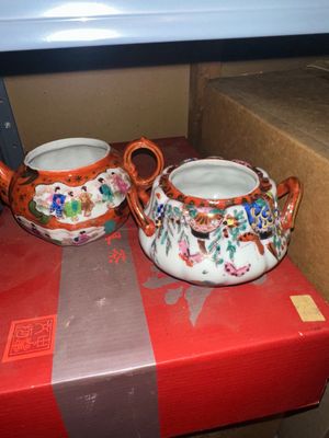 Sale Photo Thumbnail #248: Pair of vintage Japanese porcelain tea serving pieces, featuring hand-painted figures and floral motifs with orange-red accents and double handles.