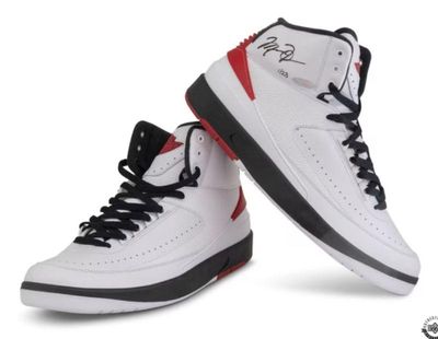 Air Jordan 2 Retro high-top sneakers in white, black, and red, featuring a signature on the ankle collar of the right shoe.