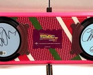 Back to the Future Part II replica hoverboard, signed by cast members on the circular footpads and featuring the movie logo in the center.