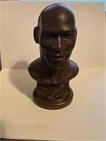Bronze-finished bust sculpture of Michael Jordan, depicting the basketball legend with a smiling expression on a circular pedestal base.
