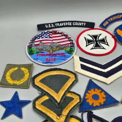LOT 58L: Collection of Vintage U.S. Military Uniform Insignia, Featuring Chevron, Unit Patches, and Pins