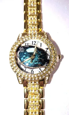 Sale Photo Thumbnail #181: Gold Colored VERY JEWELED BAND + DIAL "Celestial Green" WATCH with BAND: (Gold Tone, Clear Stones Segments 8") DIAL: (1¼" Gold Tone with Jeweled Surround + Round) BATTERY: Button 20 mm  *EXTRA BATTERY INCL.*
ALL ITEMS SHIPPED FREE