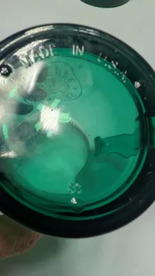 Sale Photo Thumbnail #288: This authentic vintage 1990s Starbucks mug is made in the USA from emerald-tinted, clear glass featuring an etched or embossed classic Siren logo