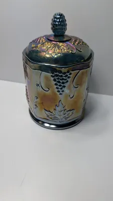 Sale Photo Thumbnail #272: This item is an original "Harvest Grape" (or simply "Harvest") pattern covered canister manufactured by the Indiana Glass Company.

Distinctive embossed clusters of grapes and large leaves, complete with a matching lid and textured finial.the pattern was 