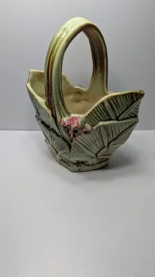 Sale Photo Thumbnail #264: The Vintage McCoy 1940s Leaves & Berries basket planter/vase is a highly collectible piece of American art pottery. Typically featuring a textured, woven-look basket with embossed botanical leaves and painted berries, these pieces are highly prized for th