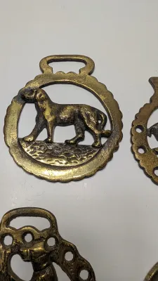 Sale Photo Thumbnail #295: Horse brass bridal medallions (or "horse brasses") are decorative, solid-brass plaques originally used to embellish the bridles and harnesses of working and parade horses. Originating in England in the mid-19th century, carters and farmers first used them