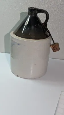 Sale Photo Thumbnail #496: It shows beautiful glaze variations and minor firing irregularities consistent with its age.  The bottom of the jug does have a chip.  

two-tone stoneware moonshine jugs are highly collectible pieces of late 19th- and early 20th-century Americana, origin