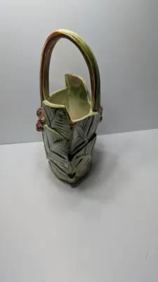 Sale Photo Thumbnail #263: The Vintage McCoy 1940s Leaves & Berries basket planter/vase is a highly collectible piece of American art pottery. Typically featuring a textured, woven-look basket with embossed botanical leaves and painted berries, these pieces are highly prized for th