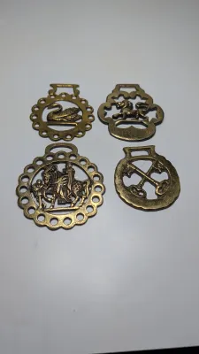 Sale Photo Thumbnail #305: Horse brass bridal medallions (or "horse brasses") are decorative, solid-brass plaques originally used to embellish the bridles and harnesses of working and parade horses. Originating in England in the mid-19th century, carters and farmers first used them