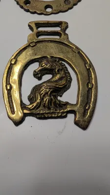 Sale Photo Thumbnail #294: Horse brass bridal medallions (or "horse brasses") are decorative, solid-brass plaques originally used to embellish the bridles and harnesses of working and parade horses. Originating in England in the mid-19th century, carters and farmers first used them