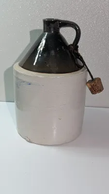 Sale Photo Thumbnail #497: It shows beautiful glaze variations and minor firing irregularities consistent with its age.  The bottom of the jug does have a chip.  

two-tone stoneware moonshine jugs are highly collectible pieces of late 19th- and early 20th-century Americana, origin