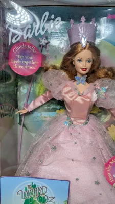 Sale Photo Thumbnail #361: A highly popular playline doll. When you raise her arm, she plays a "brrinnng" magic wand sound effect or says, "Tap your heels together three times". She features strawberry-blonde hair and a pink satin gown with star and butterfly accents