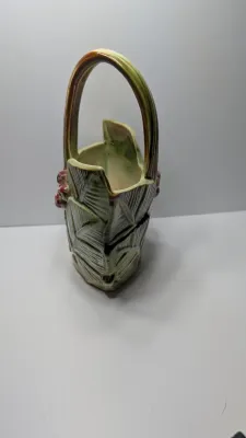 Sale Photo Thumbnail #262: The Vintage McCoy 1940s Leaves & Berries basket planter/vase is a highly collectible piece of American art pottery. Typically featuring a textured, woven-look basket with embossed botanical leaves and painted berries, these pieces are highly prized for th